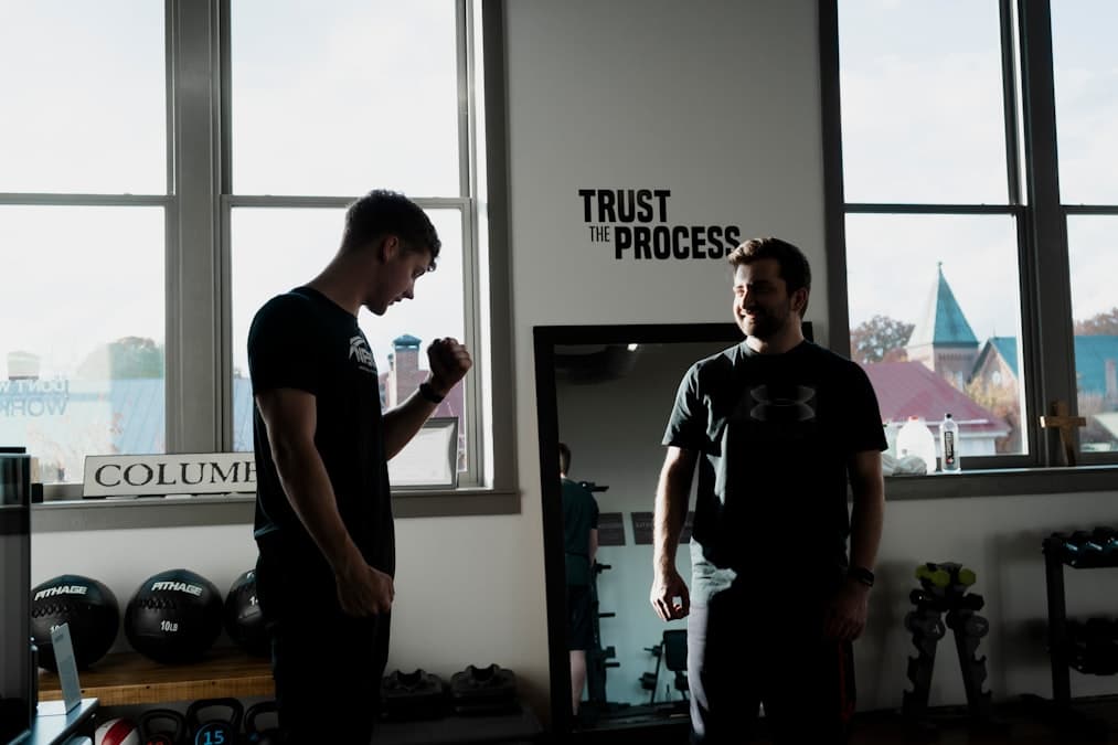 a couple of men standing in front of a window