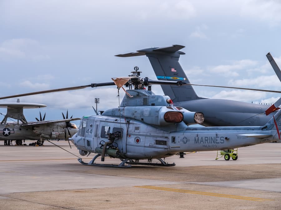 A marine helicopter is parked next to a plane.